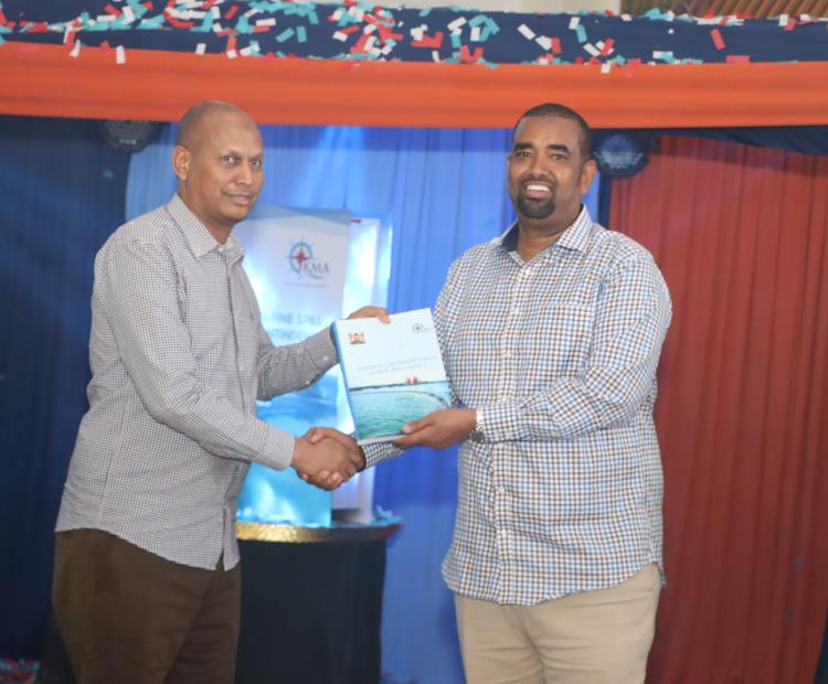 On left, the Principal Secretary State Department for Shipping and Maritime Affairs Aden Millah receiving a copy of the National Marine Spills Response Contingency Plan from the Kenya Maritime Authority Chair Ahmed Kolosh Mohamed.